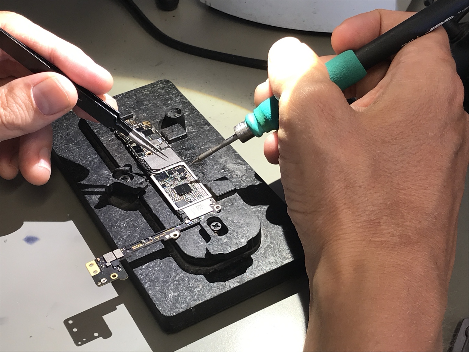 Mikrolötarbeit an einer Platine unter dem Mikroskop
